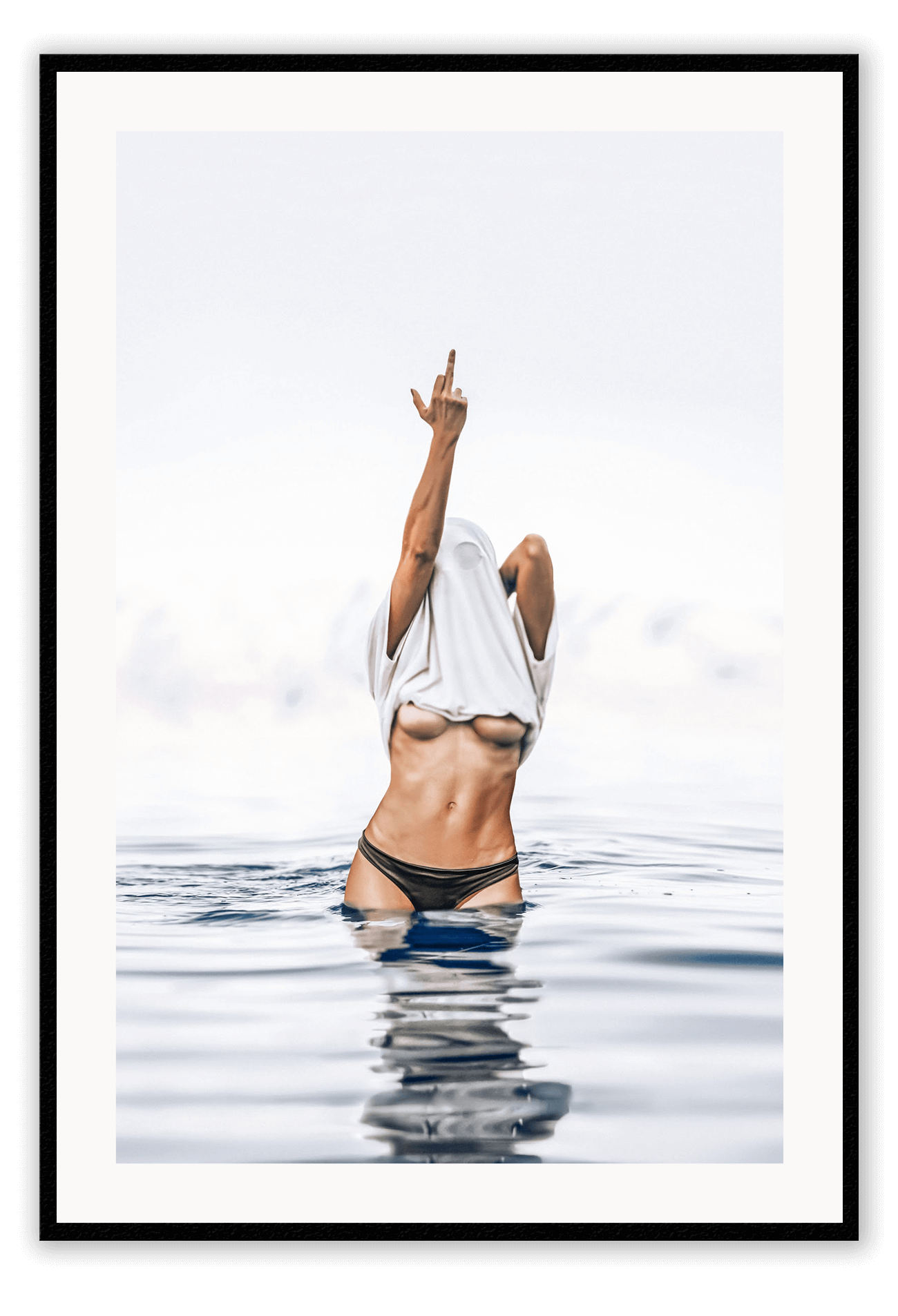 Person in black bikini standing in water with a white towel over their head, against a light gray sky.