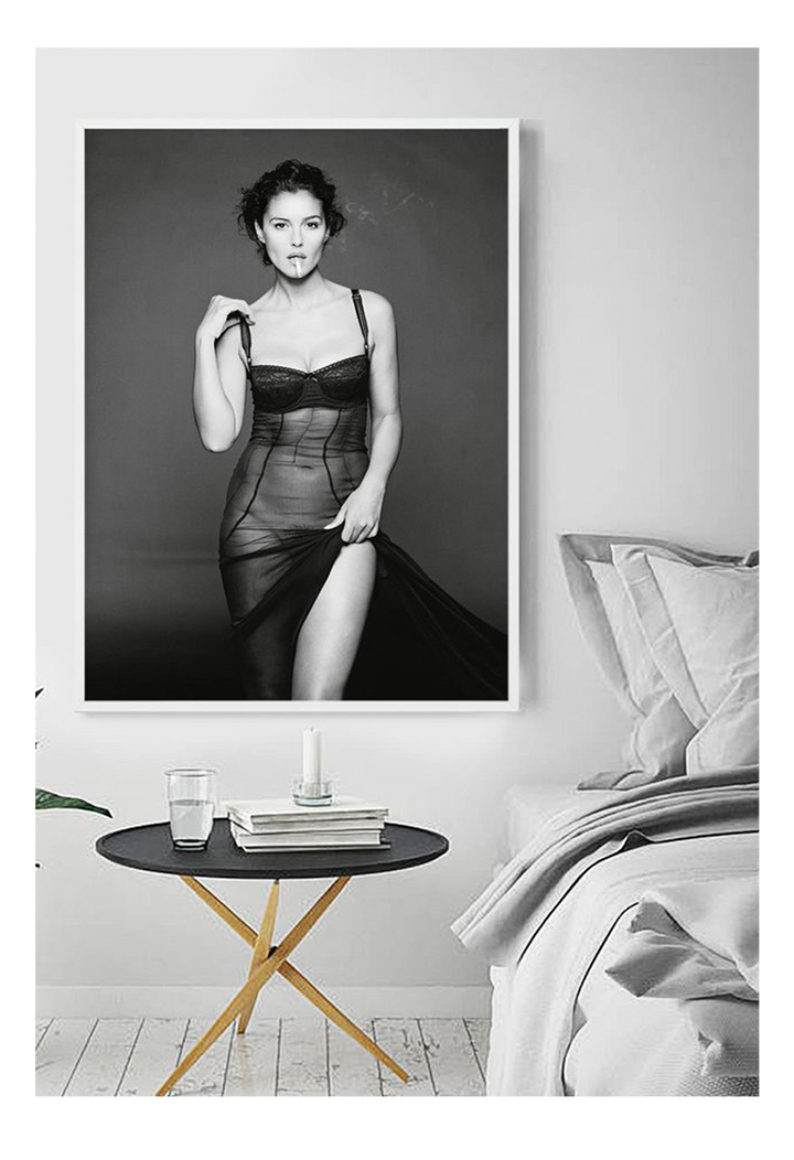 This image features a striking black and white photograph of Monica Bellucci, captured in a portrait orientation. Displayed in a high-quality, custom-made matte wood frame, the print is mounted on perspex glass that enhances its clarity and finish. HUng in a bedroom on white wall next to bed.
