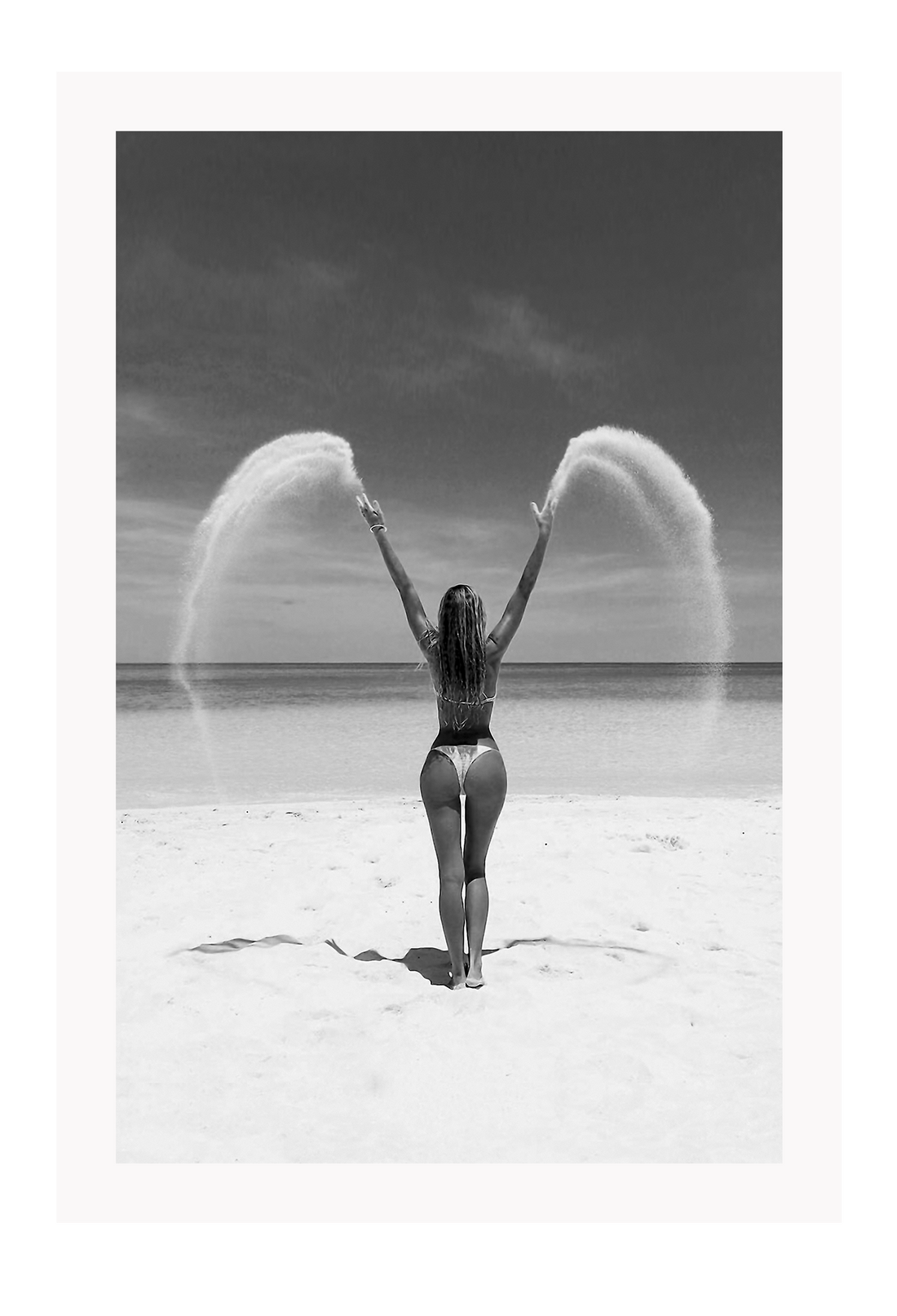 Sexy lady woman throwing sand on a beach in black and white, coastal ocean. 