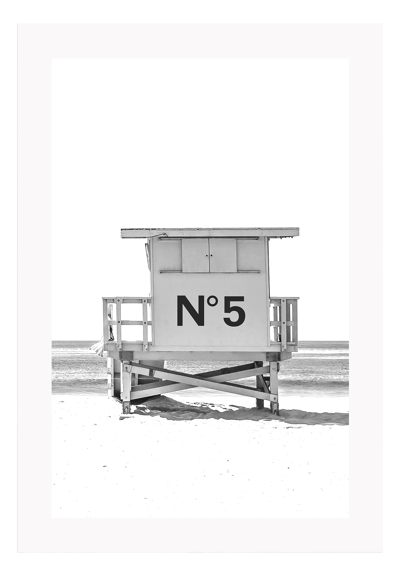 A black and white fashion wall art with black Chanel N5 fashion label on a beach cabin minimal