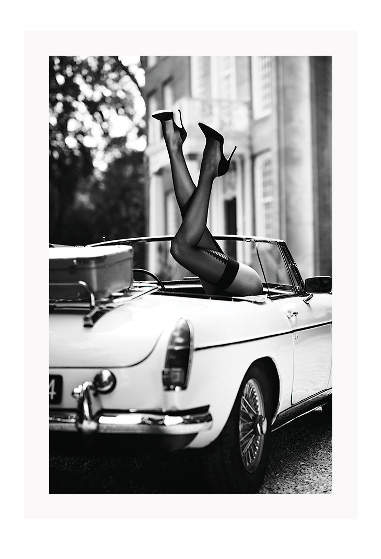 Fashion photography with womans legs coming out of a vintage car black and white lingerie sexy  