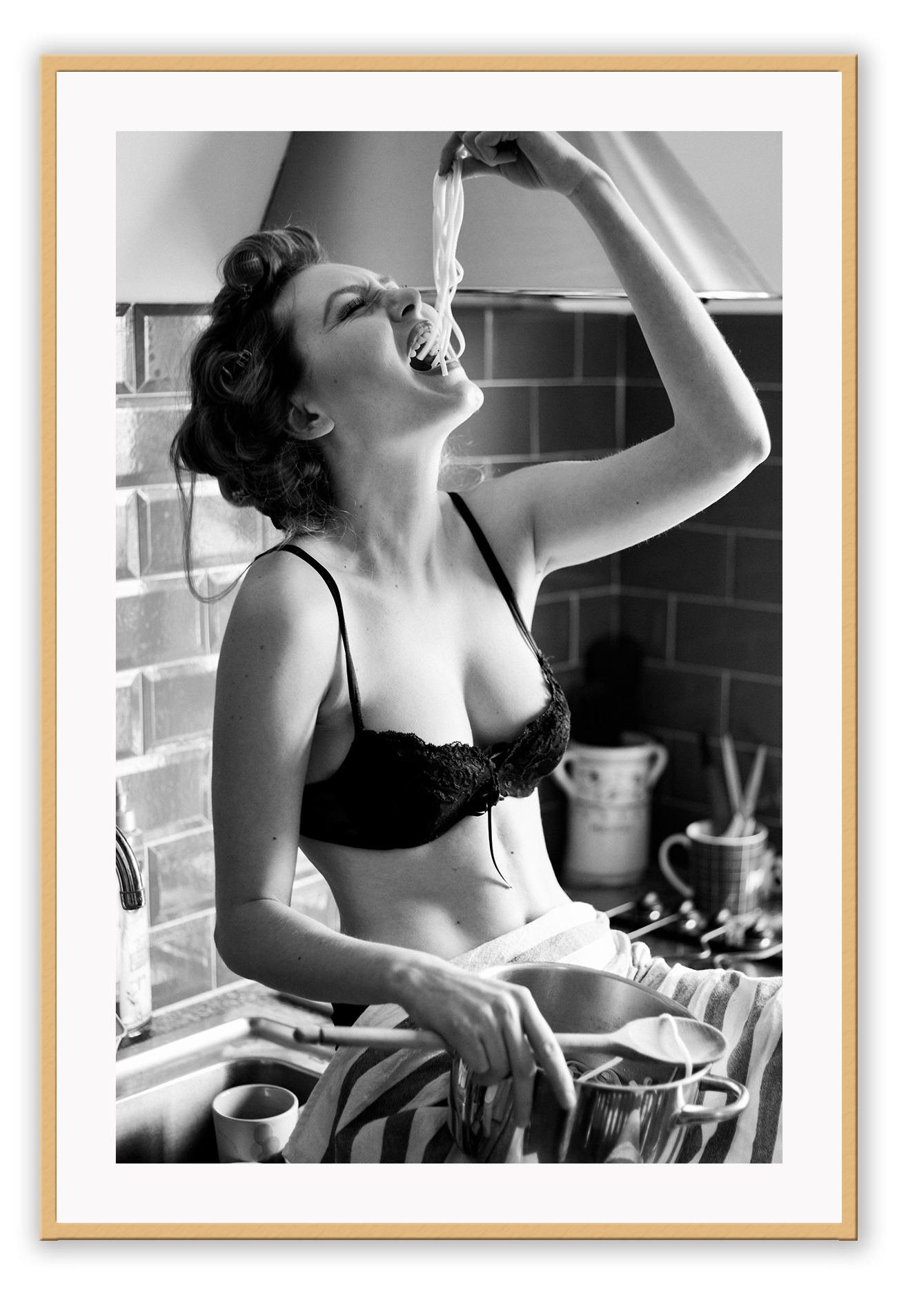 A black and white fashion wall art with a sexy lady in black lingerie eating pasta on the kitchen bench.