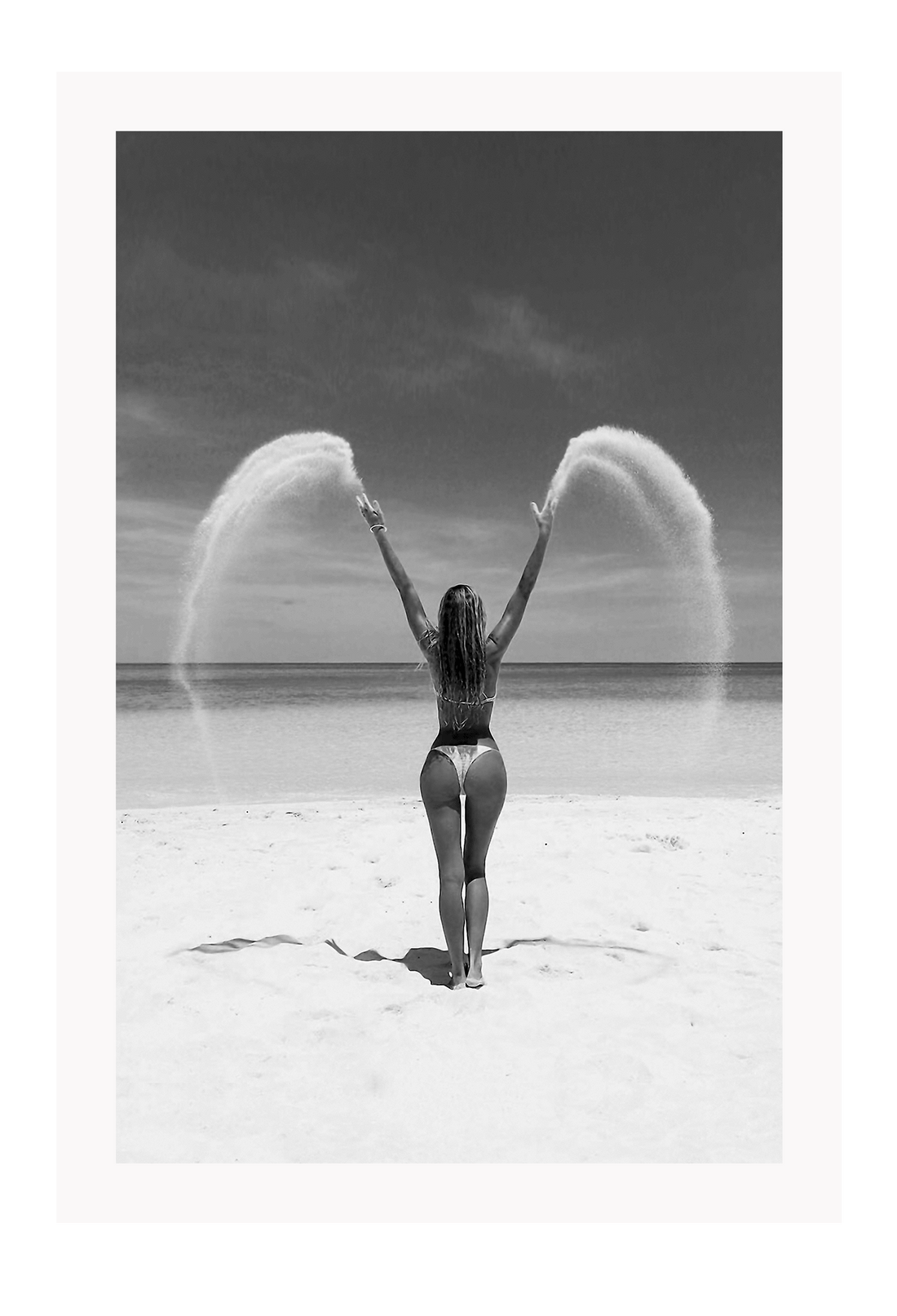 Sexy lady woman throwing sand on a beach in black and white, coastal ocean. 