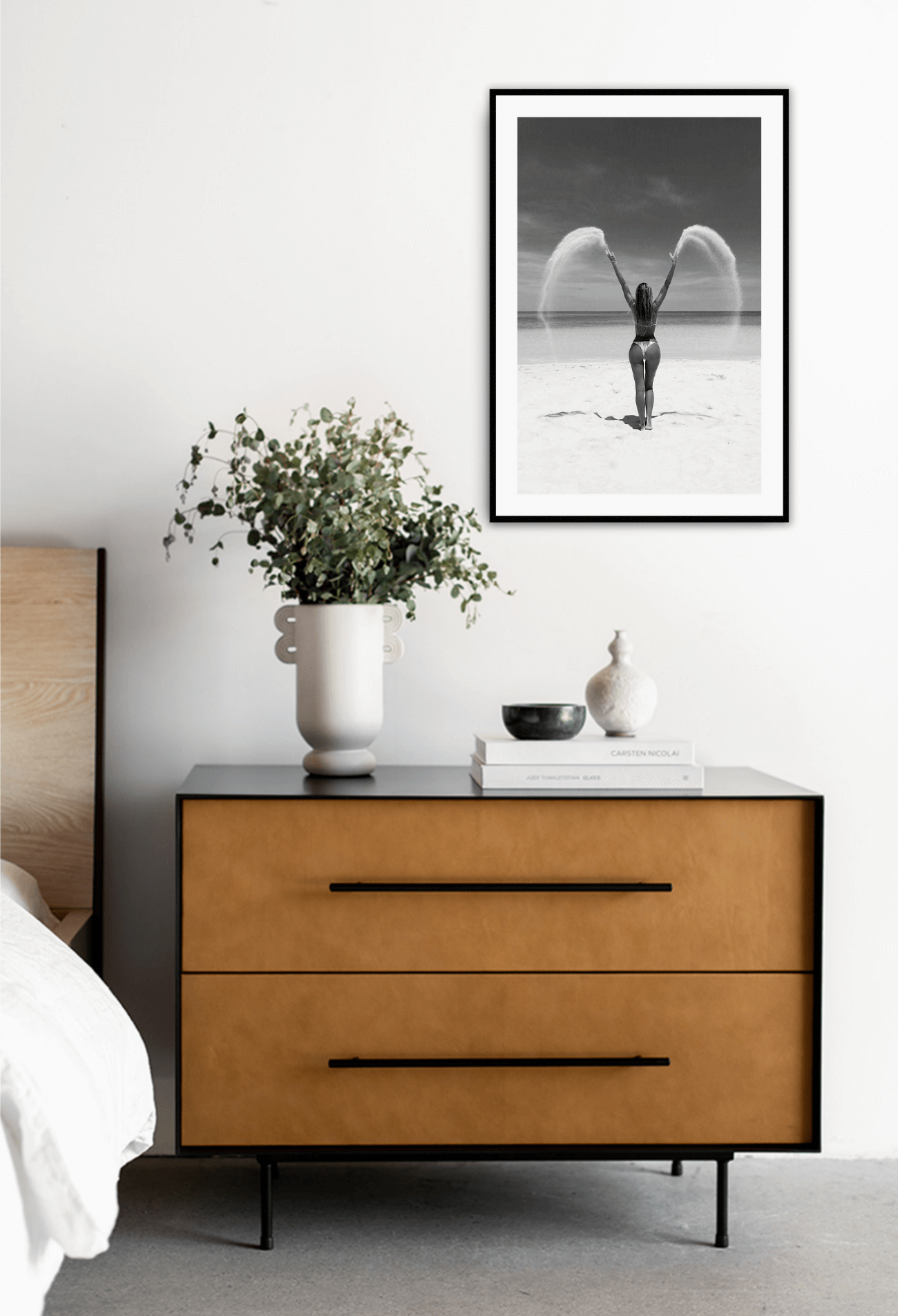 Modern bedroom with a wooden dresser, decorative items, and a framed picture on the wall.