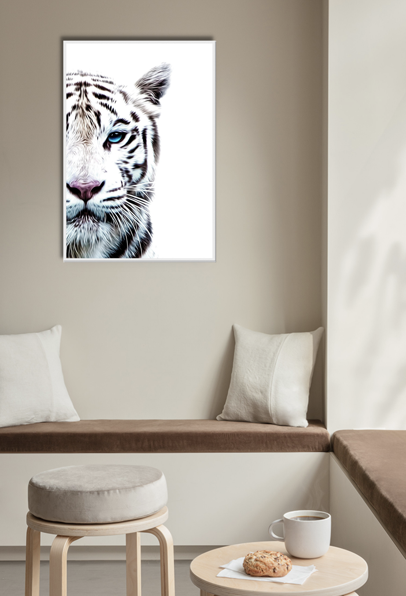 Half face of tiger photograph on white background blue eye furry pink nose. Art is hanging on a beige wall, above brown seat and white cushions.