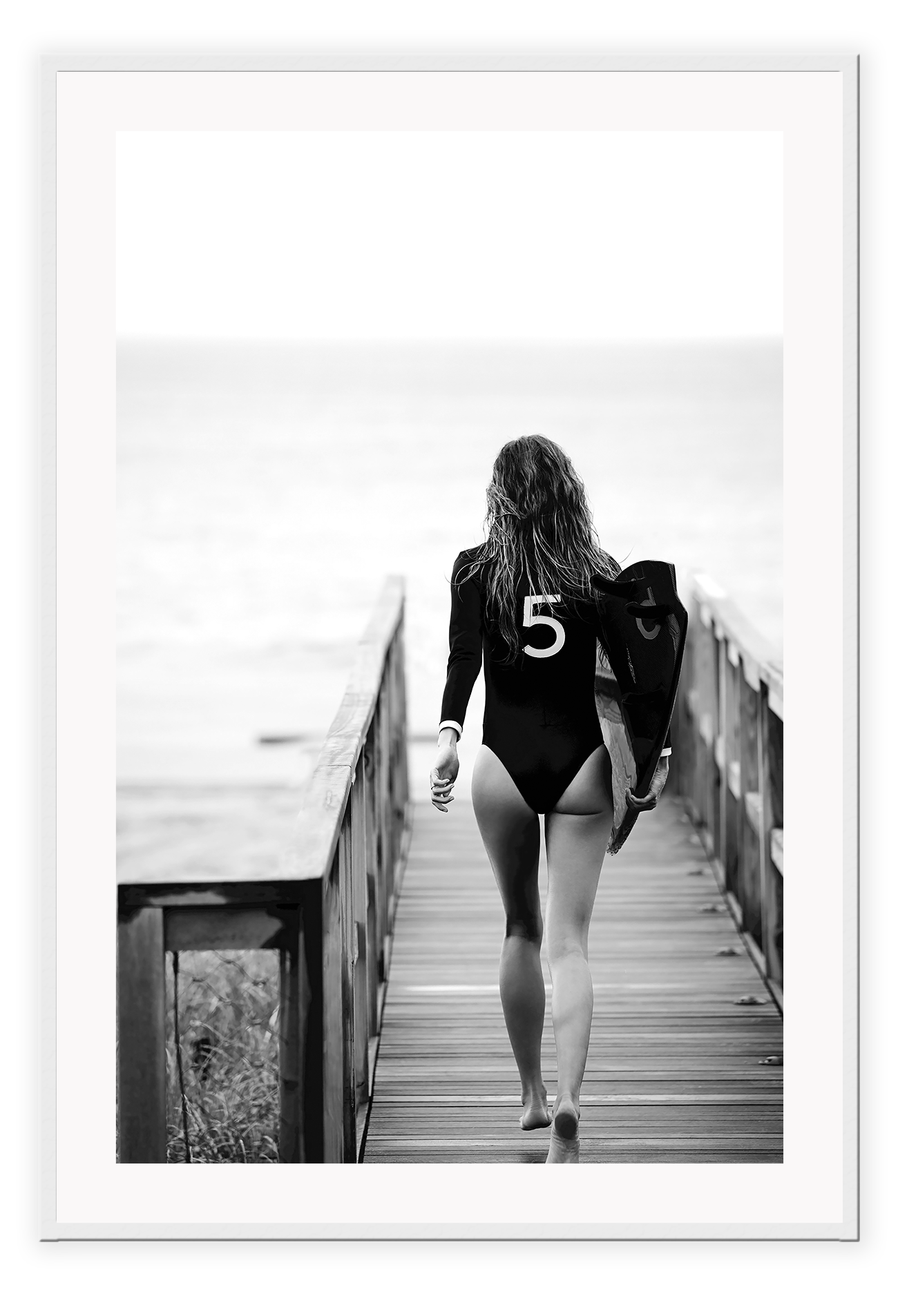 A black and white fashion wall art with fashion model Gisele Bunchen holding Chanel N5 surf board.