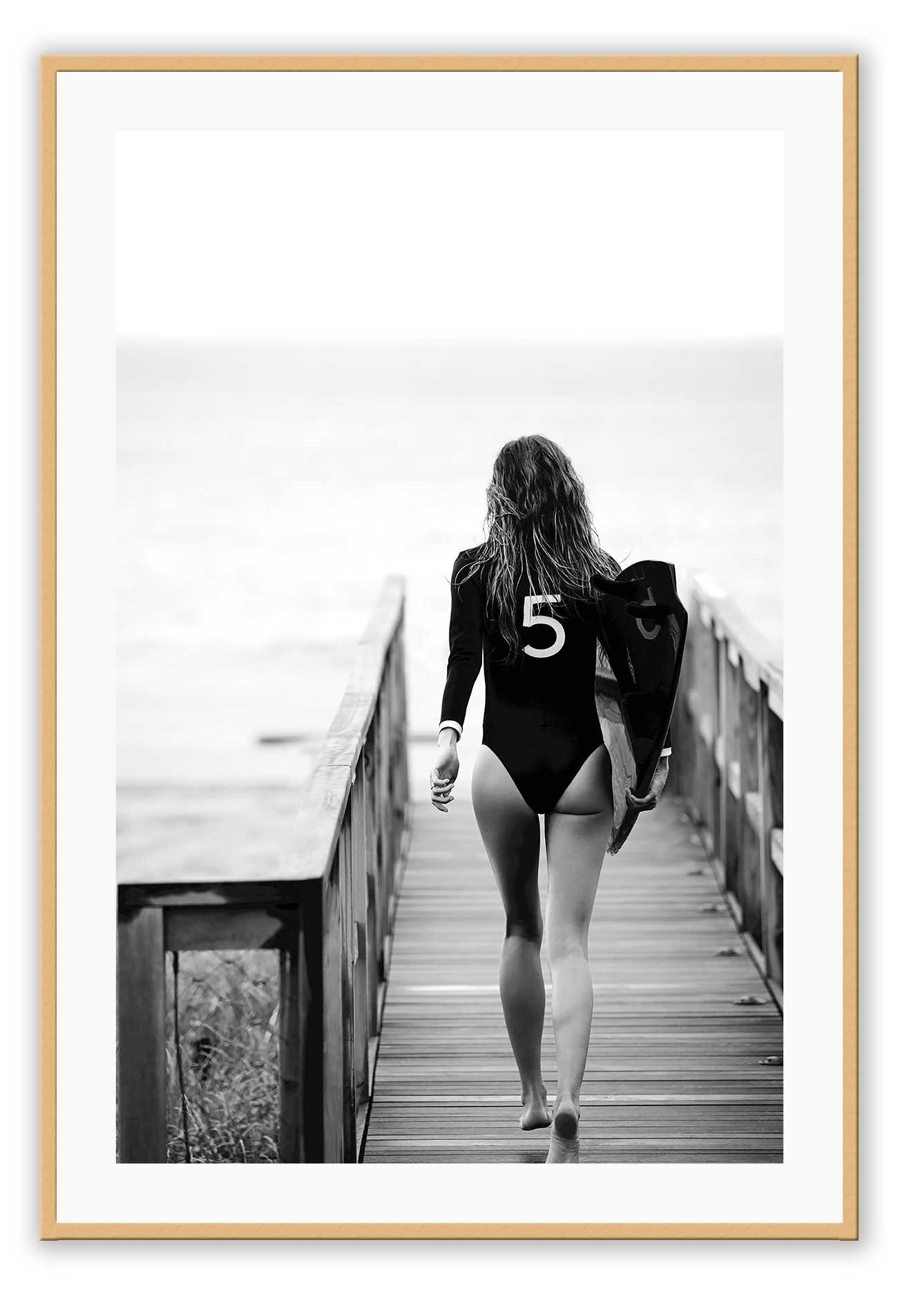 A black and white fashion wall art with fashion model Gisele Bunchen holding Chanel N5 surf board.
