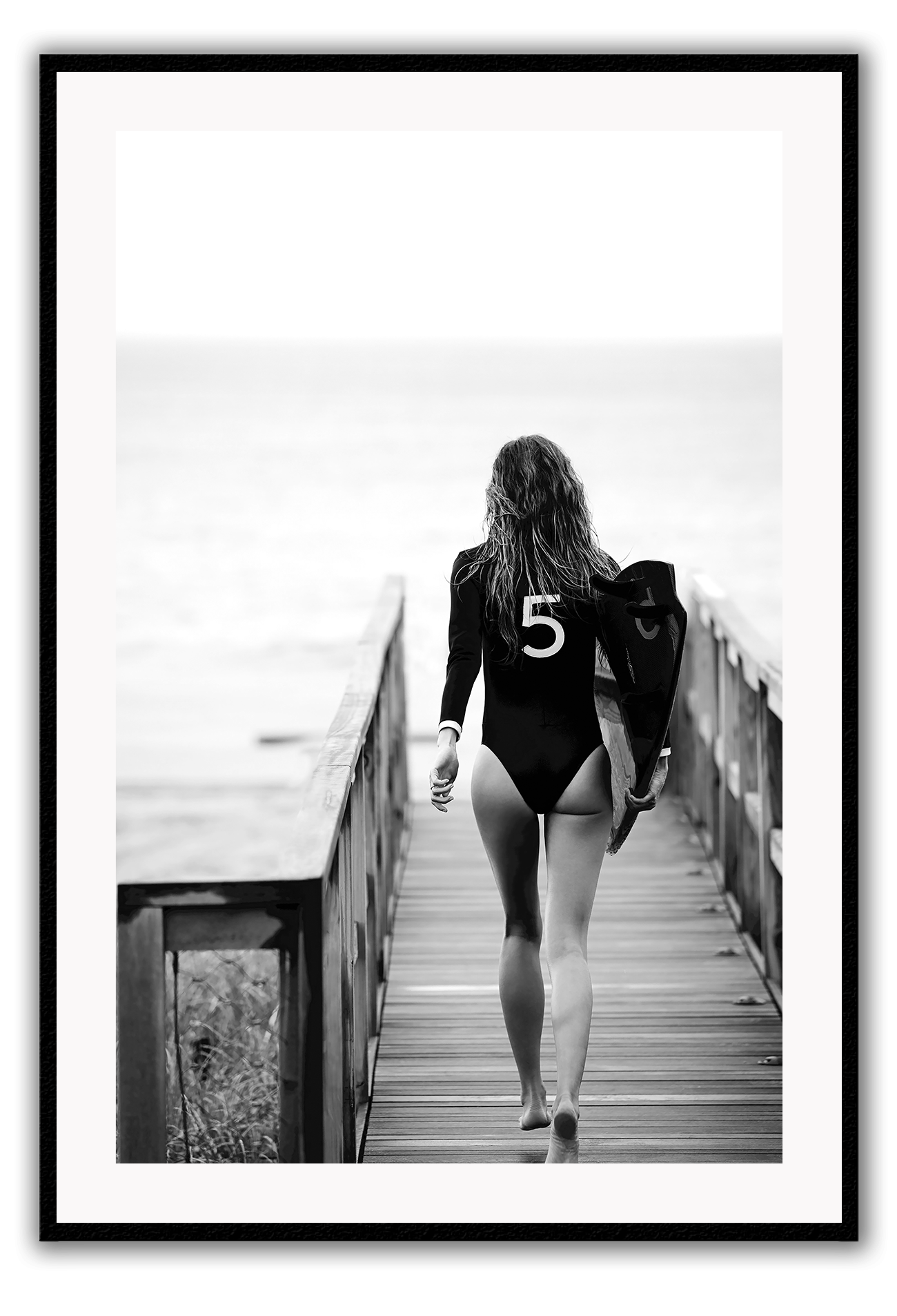 A black and white fashion wall art with fashion model Gisele Bunchen holding Chanel N5 surf board.