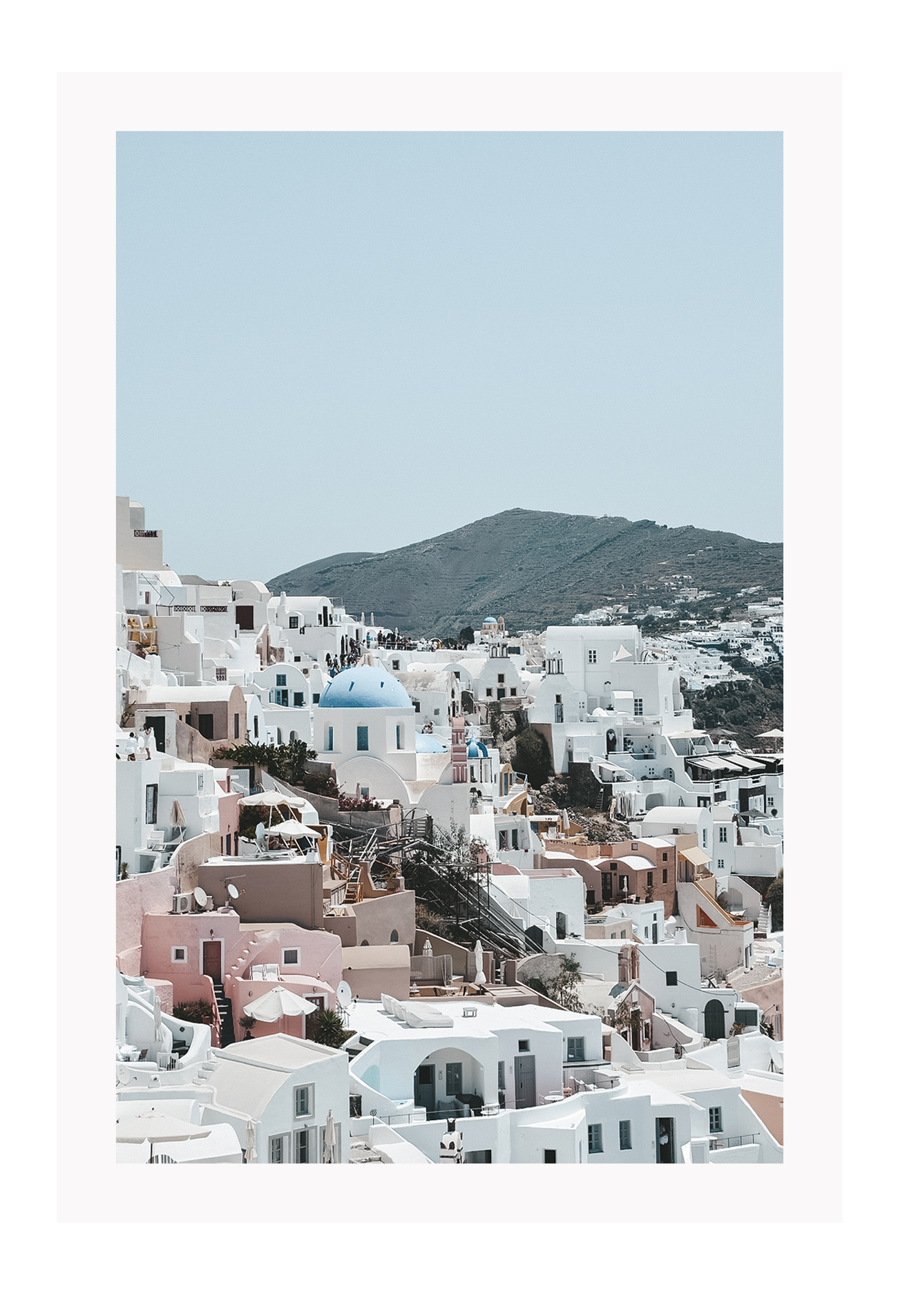 Greece, coastal architecture pastel colours blue sky mountain in background