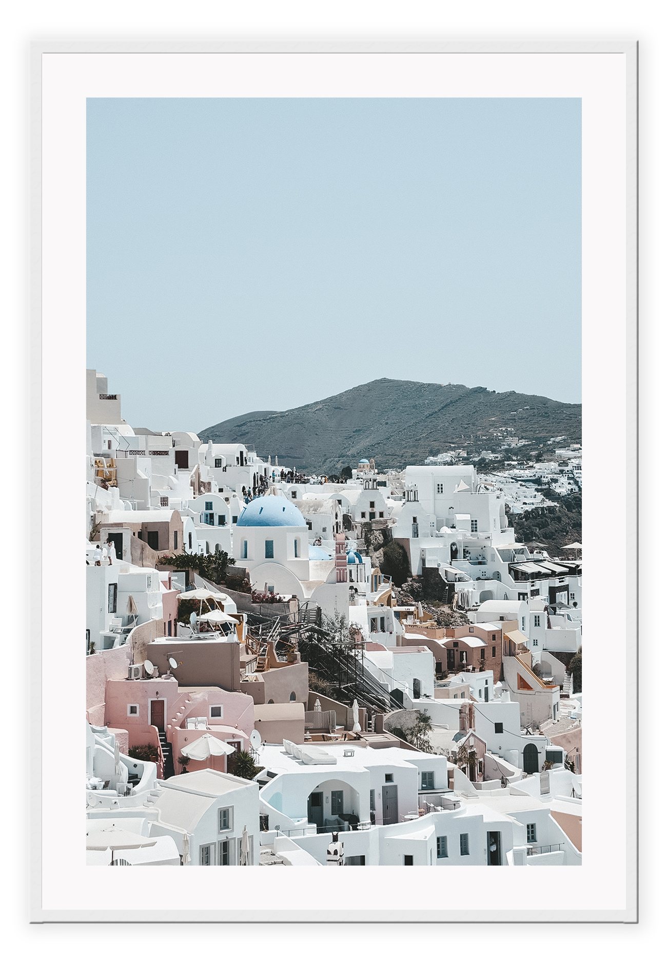 Greece, coastal architecture pastel colours blue sky mountain in background